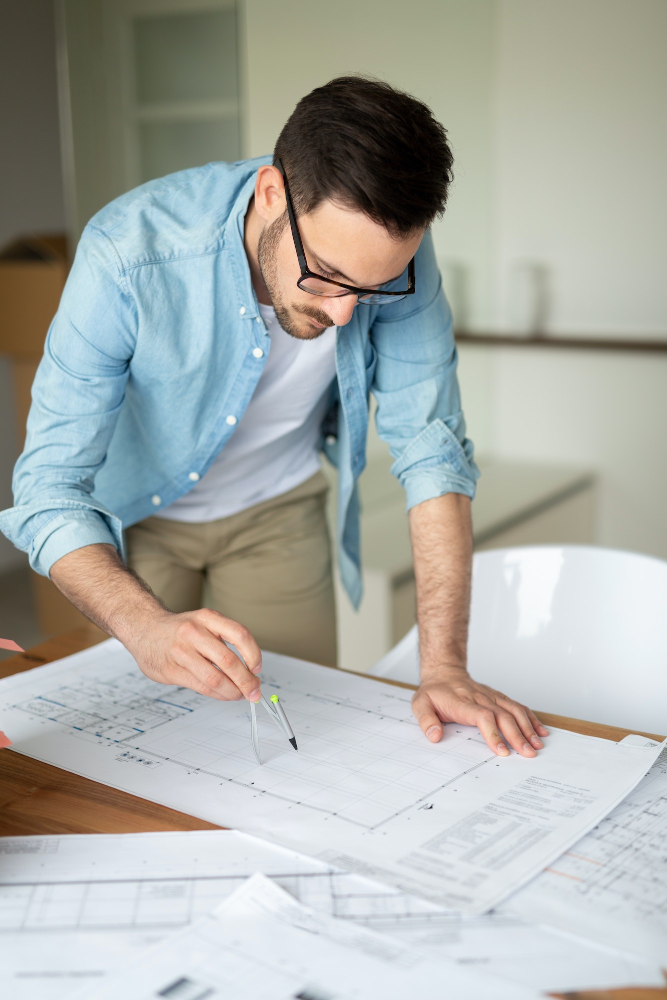 Portrait of adult architect working on plans and blueprints