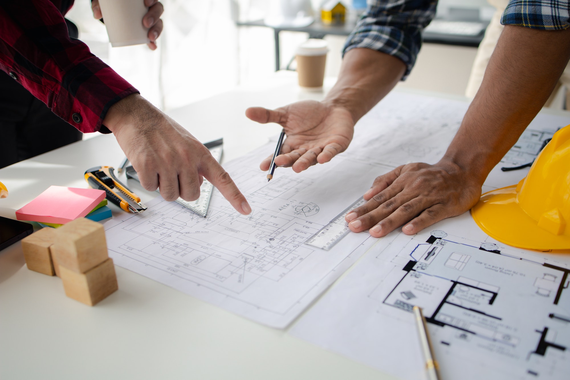 The home design architects are reviewing the house plan draft, the project commissioned by the clien